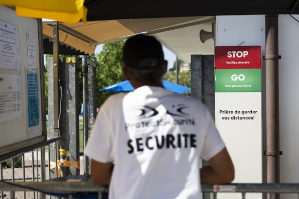 CAPTION CORRECTION: KORREKTS TO FRENCH SPELLING OF THE LOCATION PORRENTRUY NOT PRUNTRUT - A security guard stands a the entrance to the public outdoor swimming pool in Porrentruy, Switzerland, Friday, ...
