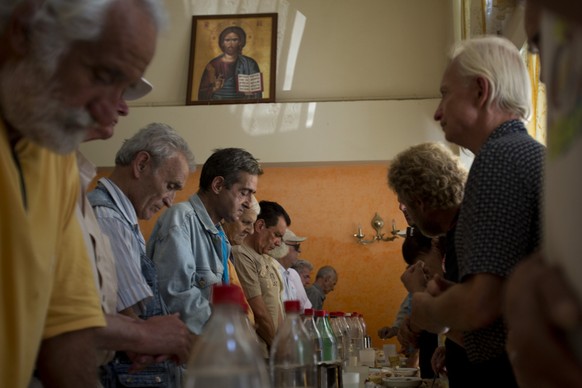 Needy people pray before eating at the Church-run Galini charity&#039;s soup kitchen in central Athens on Monday, July 6, 2015. GreeceÂs finance minister has resigned following SundayÂs referendum i ...