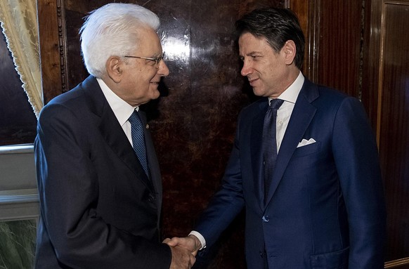 epa07800597 A handout photo made available by the Quirinal Press Office shows Italian Prime Minister Giuseppe Conte (R) and Italian President Sergio Mattarella (L) during their meeting at the Quirinal ...