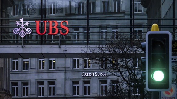 FILE - A traffic light signals green in front of the logos of the Swiss banks Credit Suisse and UBS in Zurich, Switzerland, on March 19, 2023. Swiss banking giant UBS said Tuesday it took in $28 billi ...