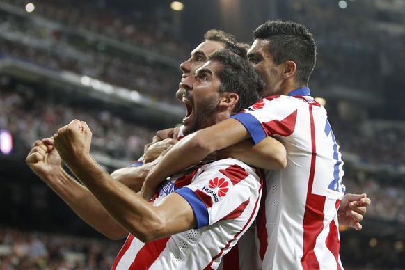 epa04360413 Atletico MadridÂ´s forward Raul Garcia (C) celebrates with his team mates after scoring against Real Madrid during the Spanish Supercup first leg match between Real Madrid and Atletico Mad ...