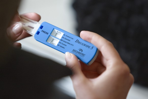 A participant of a training day for new drivers looks at a &quot;DrugWipe 5&quot; rapid drug tester in a classroom of the driving school Drive Z in Duebendorf, Switzerland, pictured on February 18, 20 ...