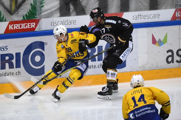 Davos's player Dario Simion, left, fights for the puck with Lugano's player Alessandro Chiesa, right, during the preliminary round game of National League Swiss Championship 2017/18 between HC Lugano and HC Davos, at the ice stadium Resega in Lugano, Switzerland, Saturday, October 14, 2017. (KEYSTONE/Ti-Press/Pablo Gianinazzi)