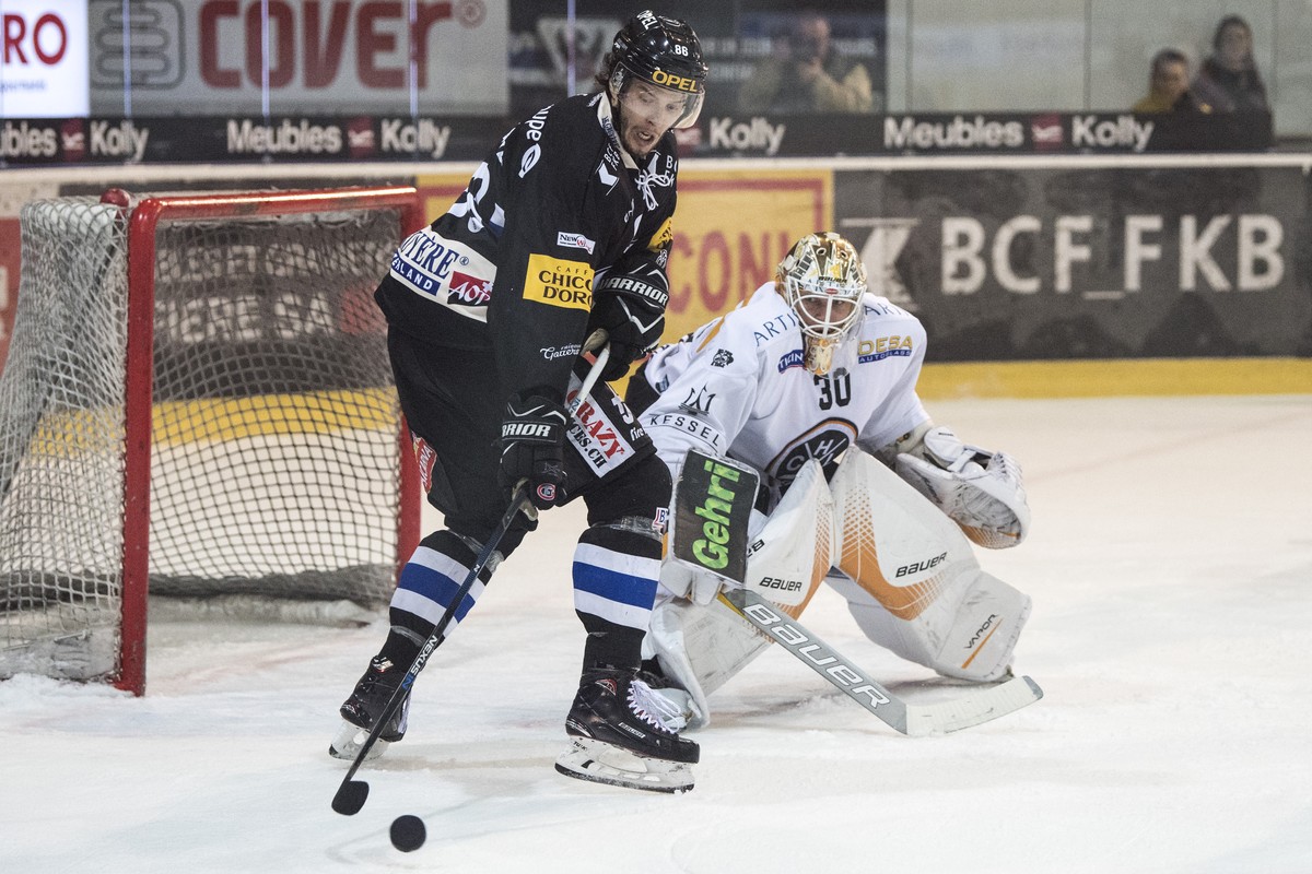 Fribourgs Julien Sprunger, links, im Duell mit Luganos Goalie Elvis Merzlikins im zweiten Eishockey Playoff-Viertelfinalspiel der National League zwischen dem HC Fribourg-Gotteron und dem HC Lugano, a ...