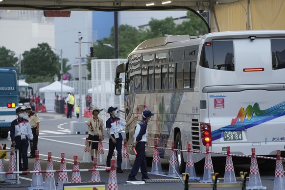 epa09353298 Security personels inspect a bus carrying athletes as it enters the Olympic Village in Tokyo, Japan, 19 July 2021. Just few days before the opening of the Tokyo Games, the Tokyo Olympic Ga ...