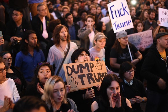 Bel Nario holds a &quot;Dump Trump&quot; sign while rallying with protesters in Oakland, California, U.S. following the election of Donald Trump as President of the United States November 9, 2016. REU ...