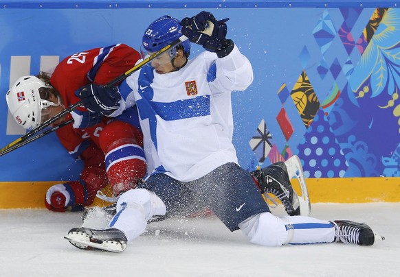 Finland&#039;s Sakari Salminen (R) checks Norway&#039;s Kristian Forsberg (L) along the boards during the third period 
of their men&#039;s preliminary round ice hockey game at the Sochi 2014 Winter O ...