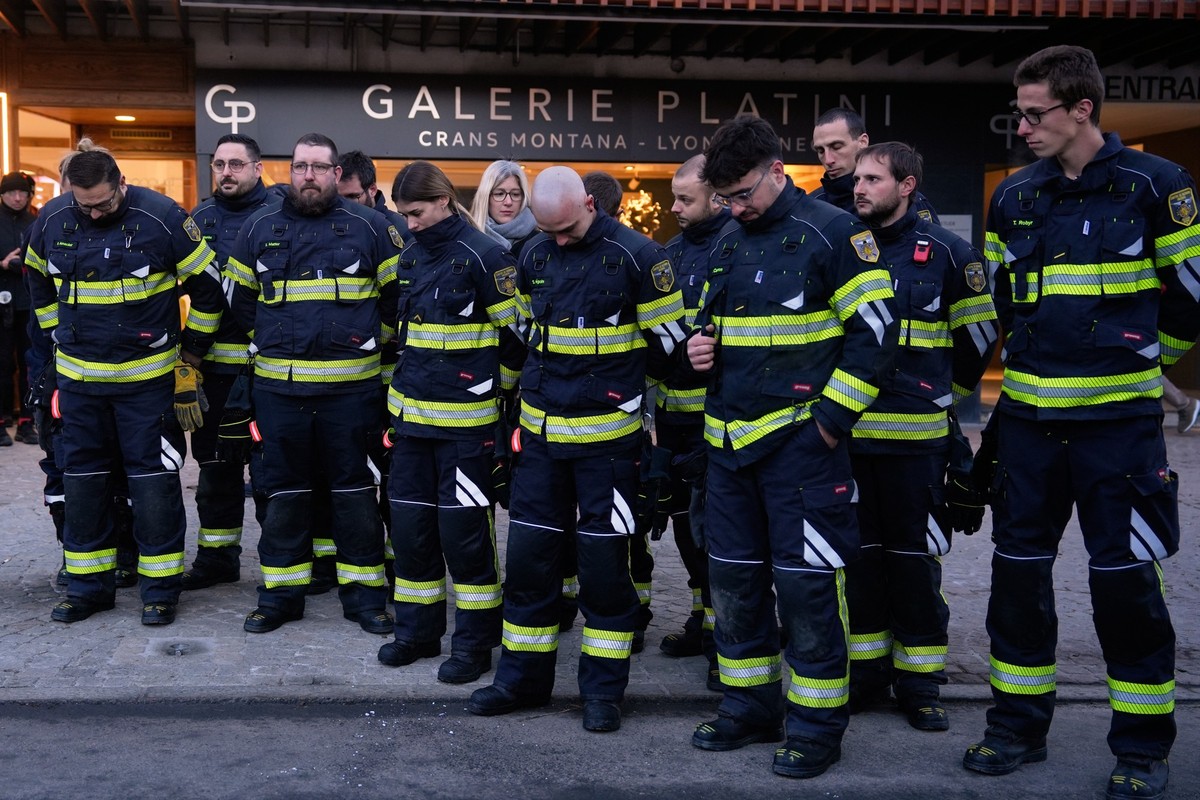 Firefighters who took part in the rescue operations on the night of the blaze stand in silence outside the sealed off area of the Le Constellation bar in Crans-Montana, Swiss Alps, Switzerland, Saturd ...