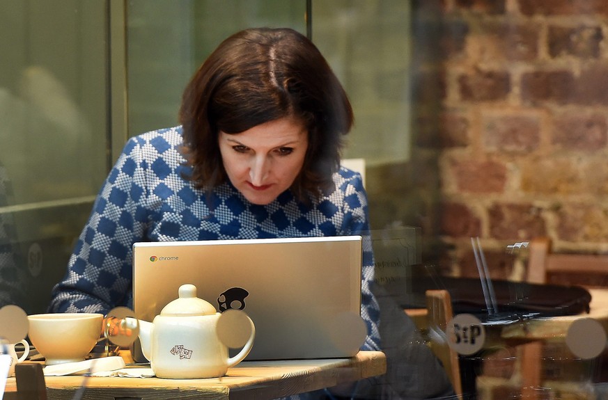 epa05101506 A customer uses the internet at a coffee shop in London, Britain, 14 January 2016. Coffee shops with public wifi networks may be obliged to store internet data for up to a year under new s ...