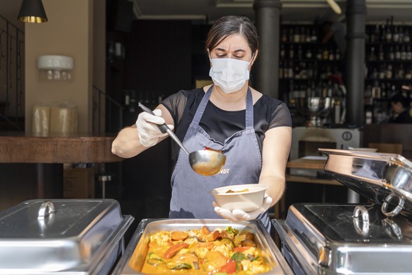 Maria Fernanda Pereira mit Gesichtsschutz und Handschuhen bei der Essensausgabe im als Notloesung eingerichteten Take Away Service des Restaurant ONO deli cafe bar in Basel, am Freitag, 8. Mai 2020. I ...