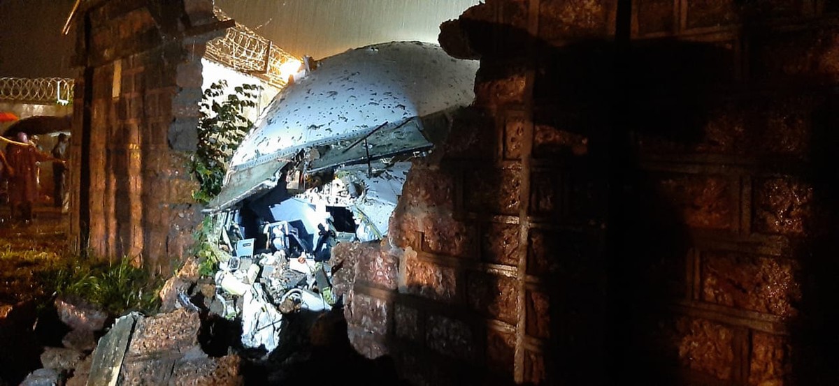 A part of the Air India Express flight is seen through a broken wall after it skidded off a runway while landing at the airport in Kozhikode, Kerala state, India, Friday, Aug. 7, 2020. (AP Photo)