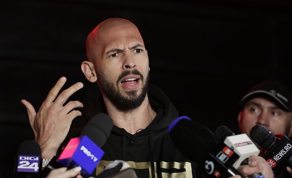 epa11980131 Former professional kickboxer and social media influencer Andrew Tate speaks with TV reporters after returning from a trip in the United States, in front of their property, in Bucharest, R ...