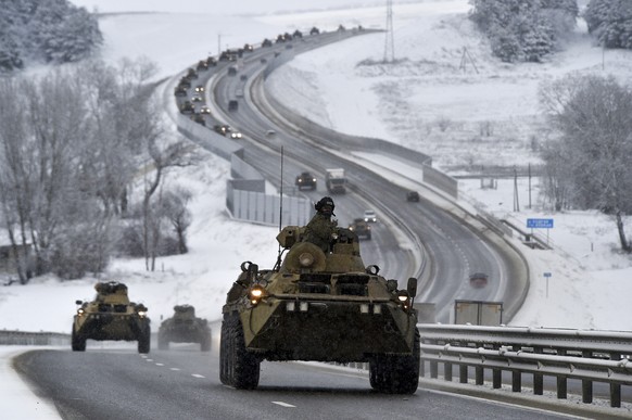 FILE - A convoy of Russian armored vehicles moves along a highway in Crimea, Tuesday, Jan. 18, 2022. With tens of thousands of Russian troops positioned near Ukraine, the Kremlin has kept the U.S. and ...