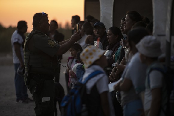 epa10622140 Migrants are processed by border guards after crossing from Mexico to the United States, in Yuma, Arizona, USA, May 11, 2023. A significant increase in the number of migrants...