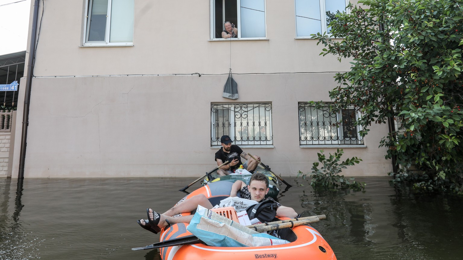epa10681878 Volunteers deliver food to local residents in a flooded area of ​​Kherson, Ukraine, June 09, 2023. Ukraine has accused Russian forces of destroying a critical dam and hydroelectric power station...