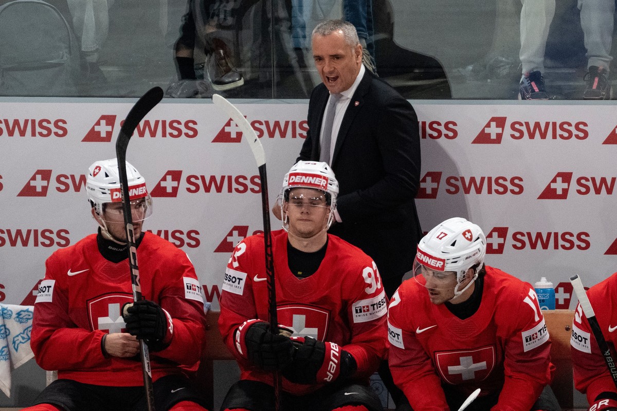Jan Cadieux, head coach of Switzerland, top, speaks during the Group A preliminary round game between Switzerland and Latvia at the men's ice hockey world championship, Saturday, May 16, 2026, in ...