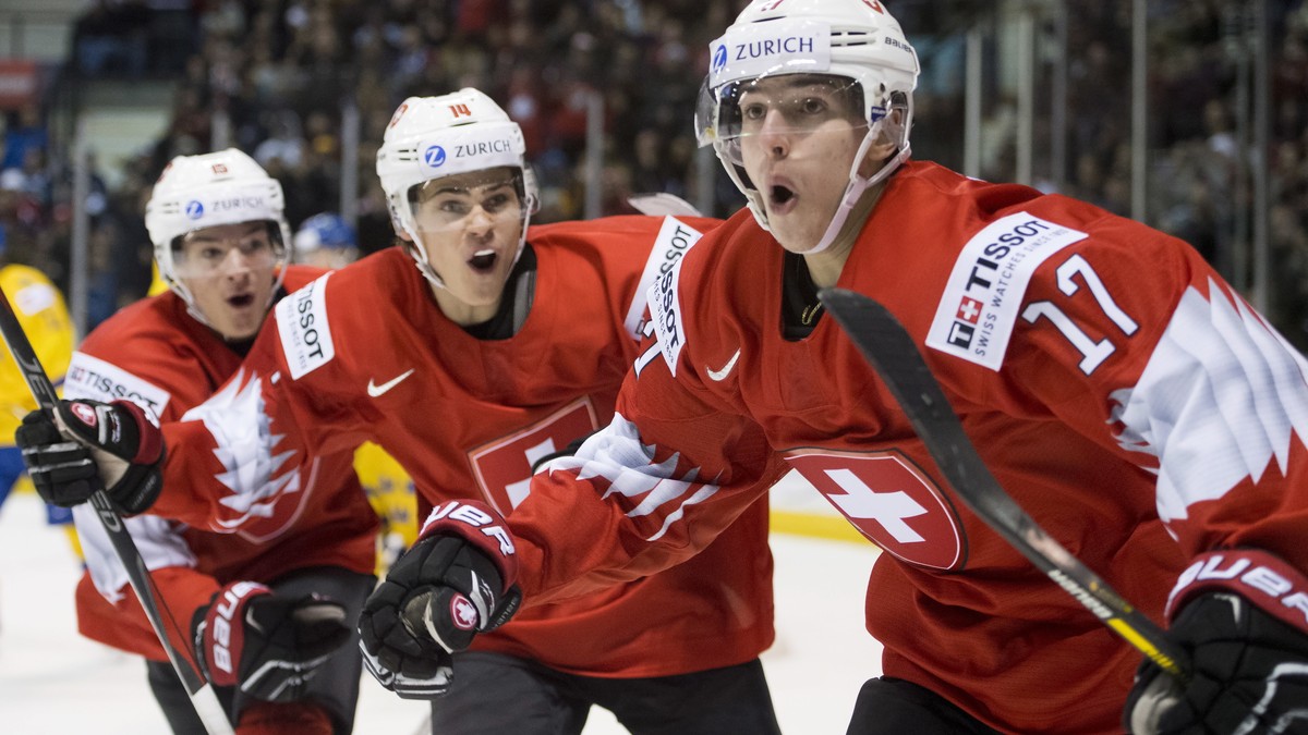 Switzerland's Luca Wyss, right, celebrates his goal past Sweden with teammates Sandro Schmid and Matthew Verboon during the second period of a world junior hockey championships game in Victoria, ...