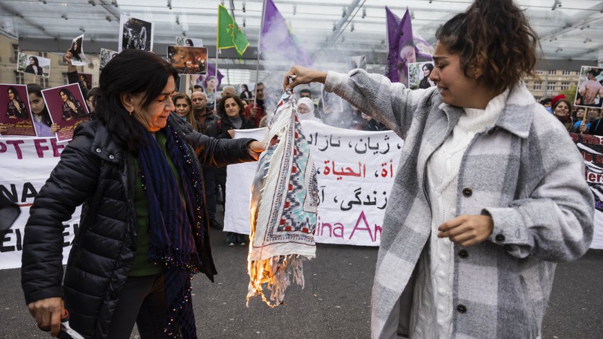 Iranian women burn their headscarfs during a rally in Bern, Switzerland, Tuesday, September 27, 2022. They were protesting against the death of Iranian Mahsa Amini, a 22-year-old woman who died in Ira ...