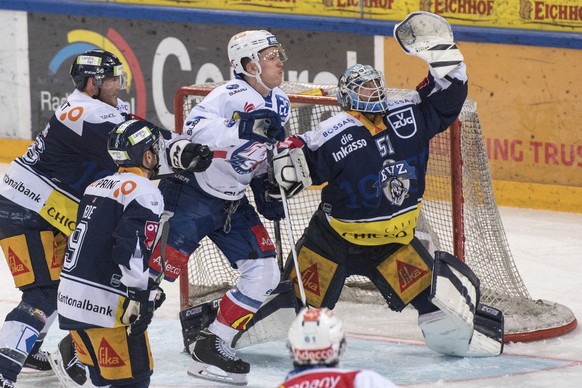 Reo Schaeppi, mitte, von ZSC im Spiel gegen Torhueter Tobias Stephan, rechts, von Zug im fuenften Eishockey Playoff-Viertelfinalspiel der National League zwischen dem EV Zug und den ZSC Lions, am Dien ...