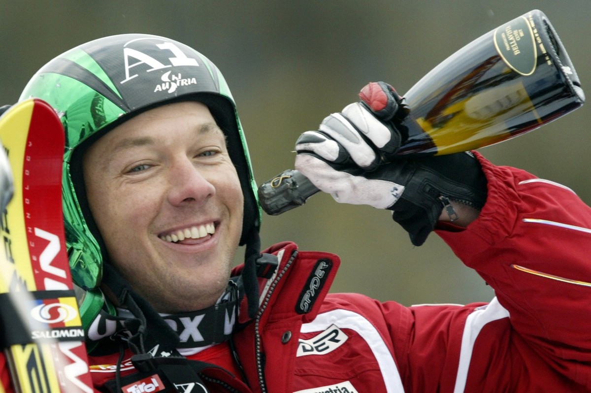 Fritz Strobl, of Austria, pretends to drink from a bottle of champagne while celebrating his first-place finish at the men's World Cup downhill in Lake Louise, Alta., Saturday, Nov. 26, 2005. (KE ...