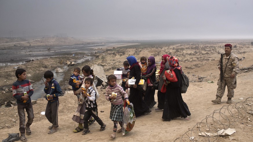Internally displaced persons clear a checkpoint in Qayara, some 50 kilometers south of Mosul, Iraq, Wednesday, Oct. 26, 2016. Islamic State militants have been going door to door in farming communitie ...