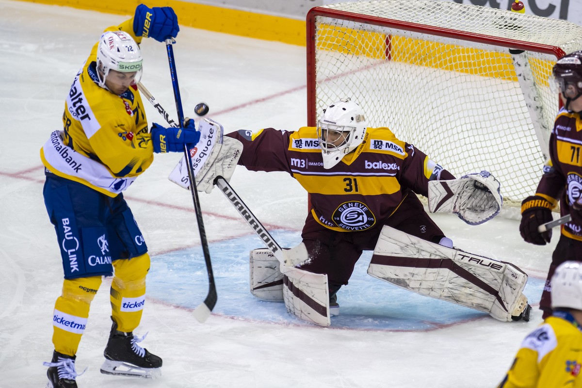 Tino Kessler (HCD), gauche, lutte pour le puck avec le gardien Nassim Jaafri-Hayani (GSHC), droite, lors du match du championnat suisse de hockey sur glace de National League entre Geneve-Servette HC, ...