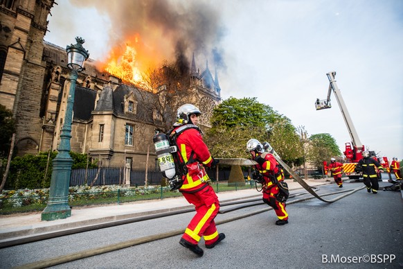 epa07509690 A handout photo made available by the Brigade de Sapeurs-Pompiers de Paris (BSPP) on 16 April 2019 shows French fire fighters in operation to extinguish a fire burning the roof of the Notr ...