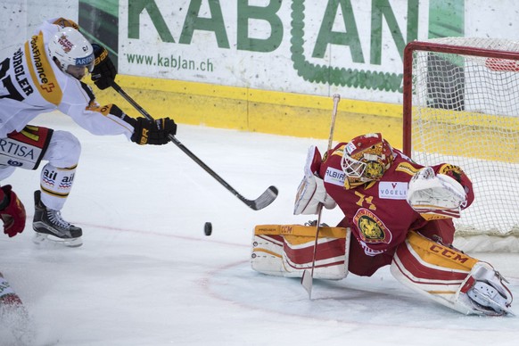 Luganos Dario Buergler, links, erzielt das 1:1 gegen Tigers Goalie Ivars Punnenovs, rechts, waehrend dem Eishockey Meisterschaftsspiel der National League A zwischen den SCL Tigers und dem HC Lugano,  ...