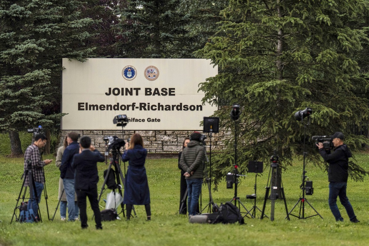 Members of the media stand outside Joint Base Elmendorf-Richardson in Anchorage, Alaska, Thursday, Aug. 14, 2025, ahead of a meeting between President Donald Trump and Russia's President Vladimir ...