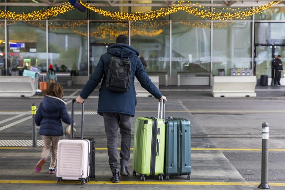 epa11797511 Flight passengers, with their luggage and ski bags, arrive in terminal 1 of the Geneva Aeroport (GVA), in Geneva, Switzerland, 29 December 2024, as Christmas and New Year holiday travelers ...
