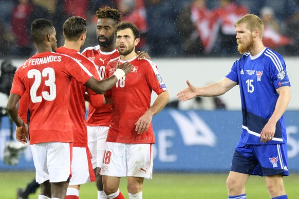 From left Swiss forward Edimilson Fernandes, Swiss defender Johan Djourou and Swiss midfielder Admir Mehmedi, celebrates next to Faroese defender Odmar Faero, right, after the 2018 Fifa World Cup grou ...