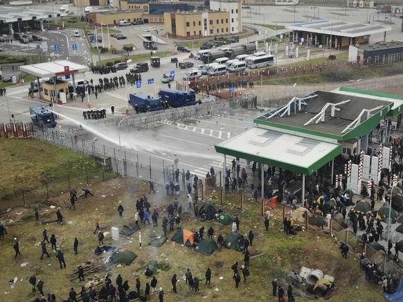 FILE - In this image taken with a drone Polish servicemen use a water cannon during clashes between migrants and Polish border guards after they were attacked with stones by migrants at the Belarus-Po ...