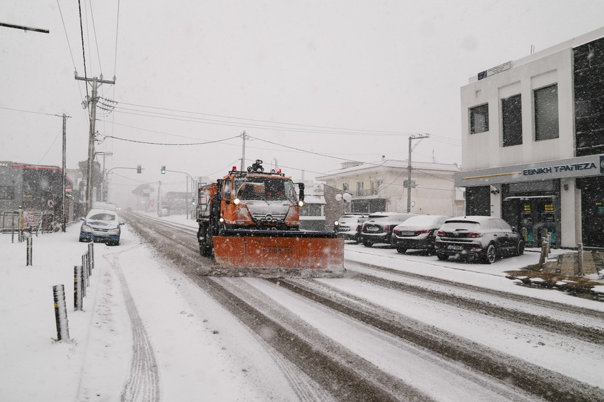 A snow plow vehicle removes snow from a street in Agios Steganos, north of Athens ,on Monday, Jan. 24, 2022.The wave of bad weather hitting Greece is forecast to continue through Tuesday, and has seen ...