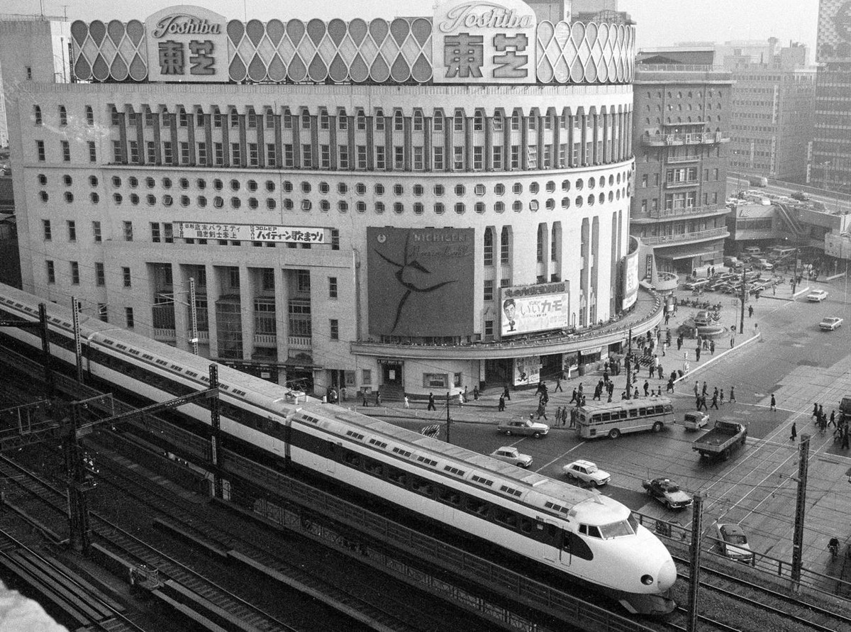 FILE - In this Dec. 21, 1964, file photo, Japan's Shinkansen, a high speed train, passes by Tokyo's Nichigeki Theater in Yurakucho district shortly after leaving Tokyo Station in Tokyo. The  ...
