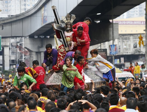 Filipino Catholic devotees jostle to get closer to the image of the Black Nazarene during a thanksgiving procession on New Year&#039;s eve in Manila, Philippines, Thursday, Dec. 31, 2015. The processi ...