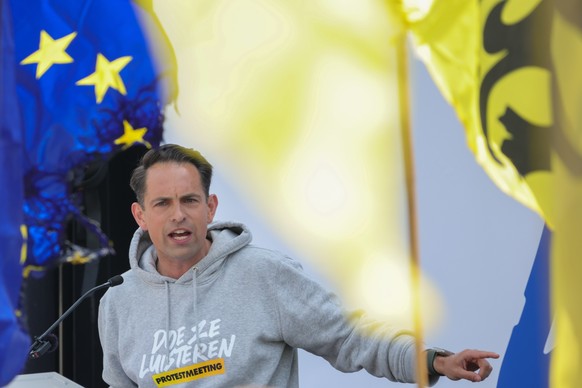 epa10662008 Tom Van Grieken, leader of the Flemish right-wing party Vlaams Belang, addresses the crowd next to a partially burnt EU flag during an event marking the end of his walking tour from Ostend ...