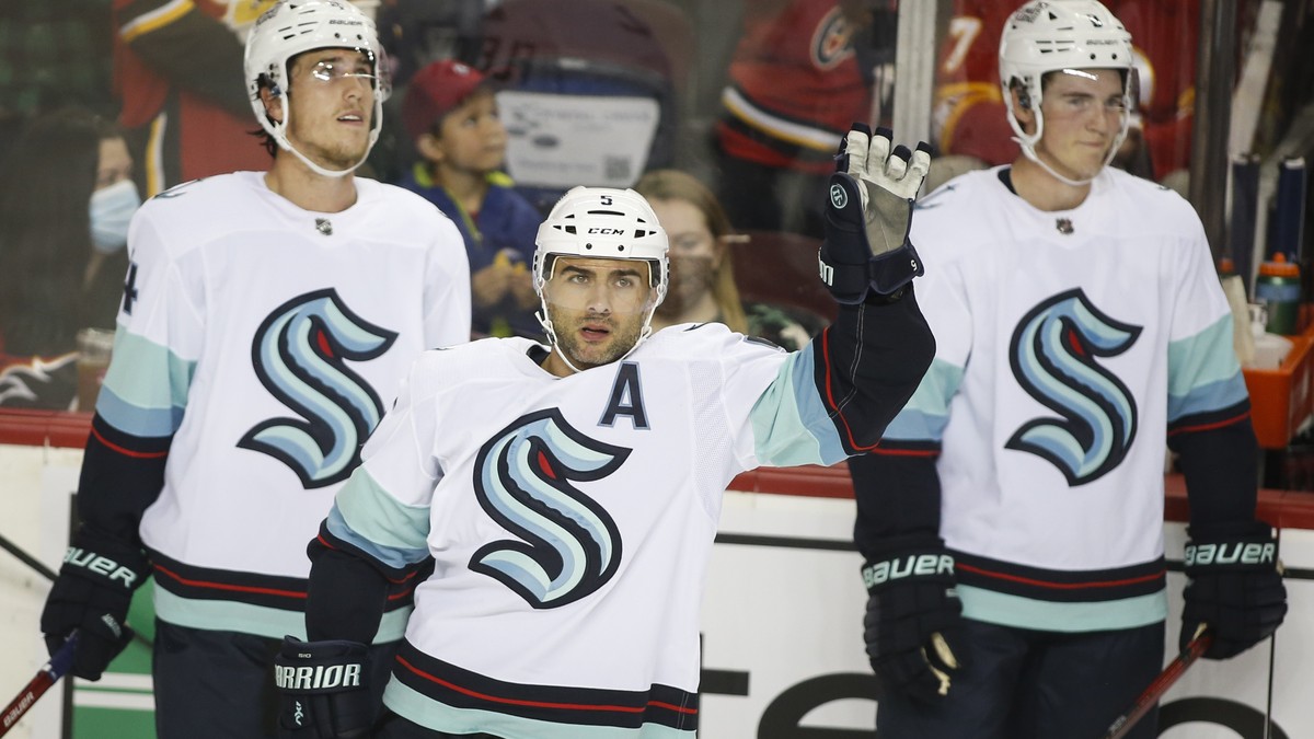 Seattle Kraken's Mark Giordano, center, waves to the crowd during a break in play against the Calgary Flames during the first period of a preseason NHL hockey game in Calgary, Alberta Wednesday,  ...