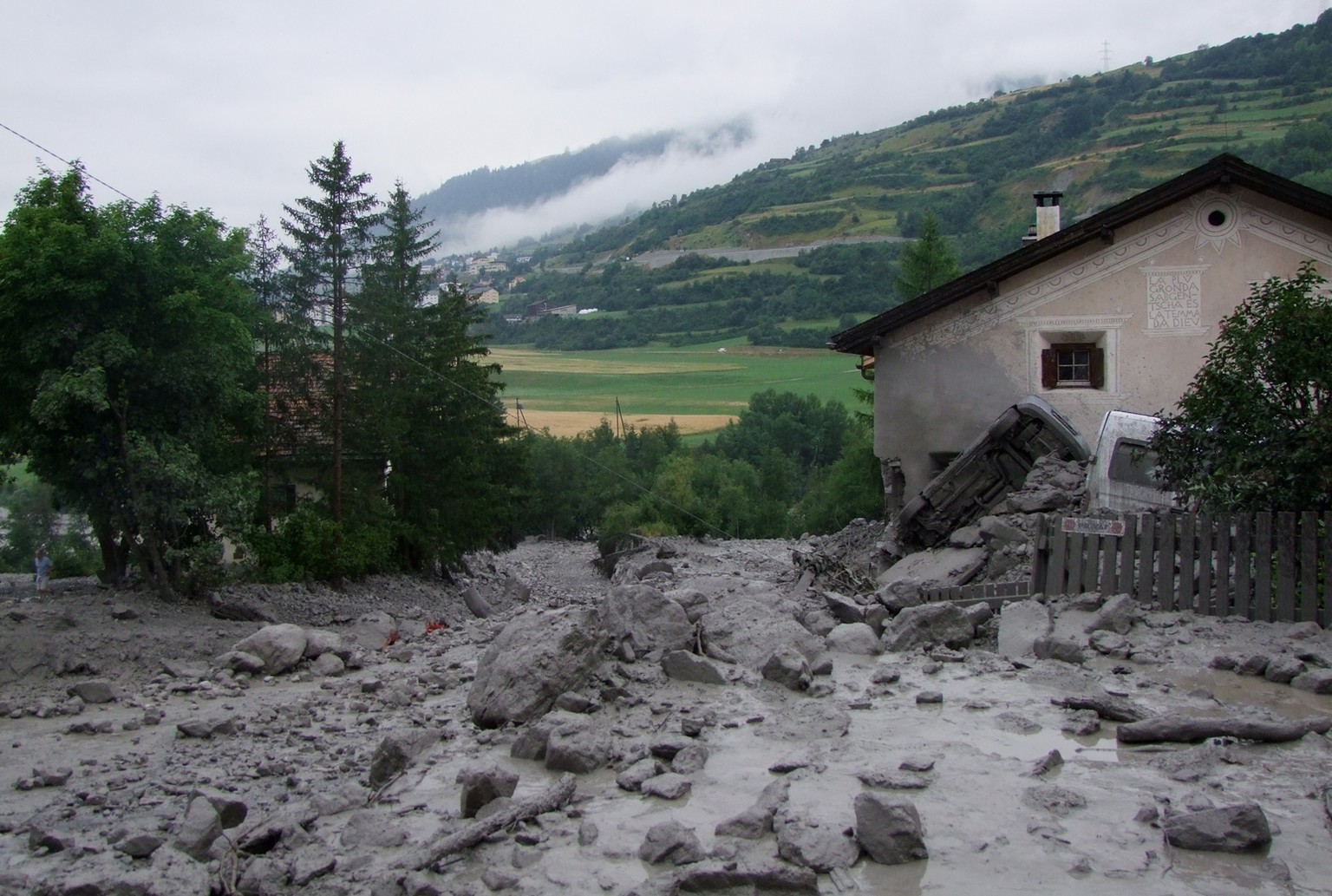 Die Lawine aus Schlamm und grossen Felsbrocken wälzte sich zwischen den Gebäuden einer kleinen Ansiedlung durch. Autos wurden beiseite geschoben und umgekippt.