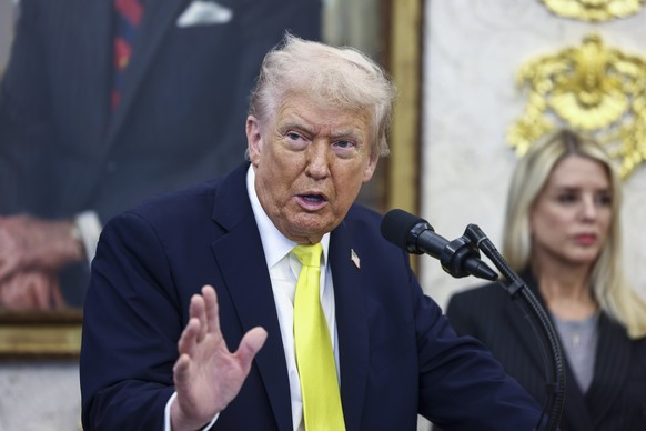 epa12456670 US President Donald Trump, with Attorney General Pam Bondi (R), responds to a question from the news media during a press conference in the Oval Office of the White House in Washington, DC ...