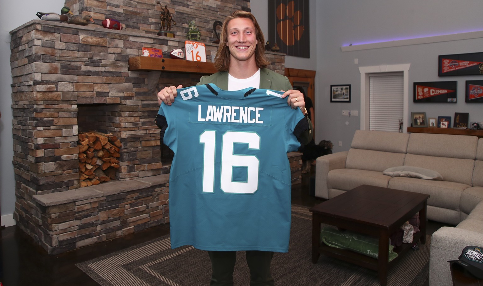 Clemson quarterback Trevor Lawrence holds up a jersey after being selected by the Jacksonville Jaguars with the first pick in the NFL football draft, Thursday, April 29, 2021, in Seneca, S.C. (Logan B ...