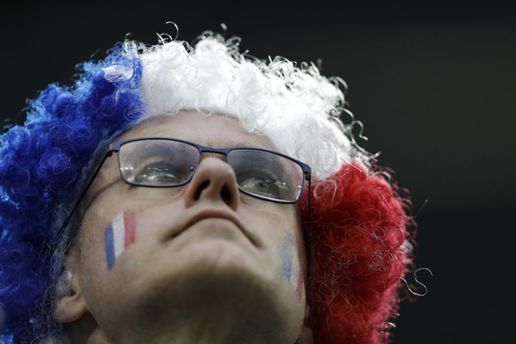 A French fan wear a tricolour wig in the national colours of France as he looks out from the stands before the start of the semifinal match between France and Belgium at the 2018 soccer World Cup in t ...