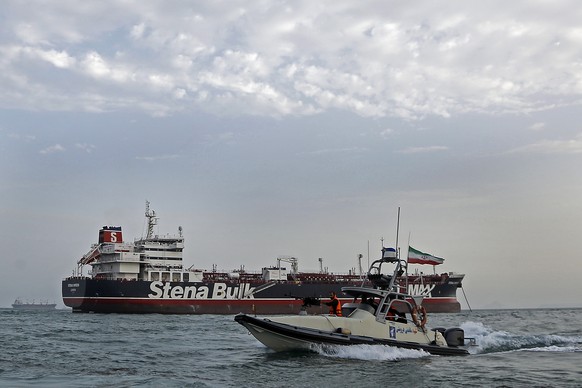 epa07731992 An Iranian Revolutionary Guard jet boat sails around the seized British-flagged tanker Stena Impero in Bandar Abbas, southern Iran, 21 July 2019. Media reported that Iranian Revolutionary  ...