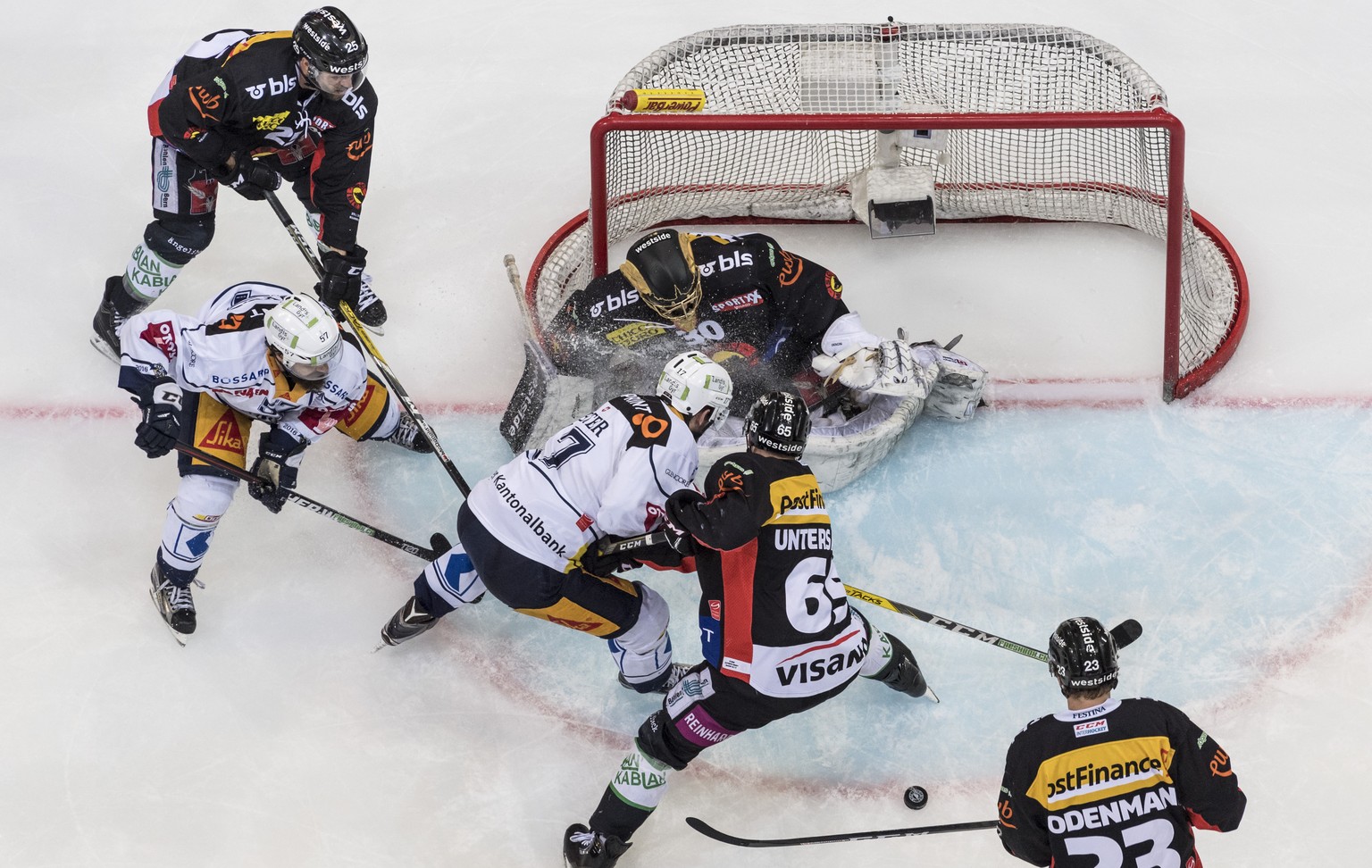 Zugs Fabian Schnyder, links, und Peter Emanuel, bringen Unruhe vors Tor von Berns Goalie Leonardo Genoni, im dritten Eishockey Playoff-Finalspiel der National League A zwischen dem SC Bern und dem EV  ...