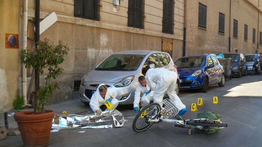 epa05980786 Police experts search for evidence at the site where the body of the mafia boss Giuseppe Dainotti, 67, lies on the ground at D&#039;Ossuna street, in Palermo, 22 May 2017. The Mafia boss w ...