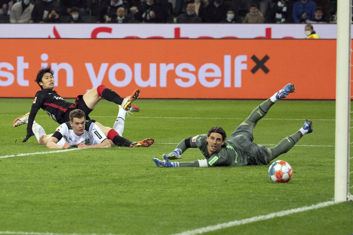 Frankfurt's Daichi Kamada scores past Monchengladbach's Matthias Ginter, top left, and goalkeeper Yann Sommer during the Bundesliga soccer match between Monchengladbach and Eintracht Frankfu ...
