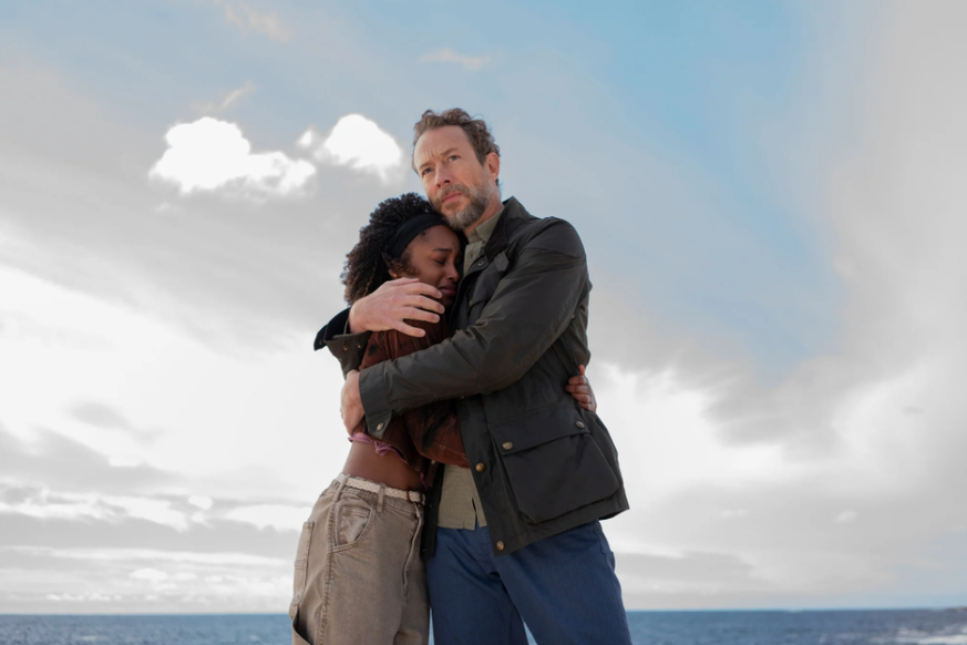 Jacobs Vater Saul (Kris Holden-Ried) hält Lou (Fathia Youssouf ) im Arm, die ihre Mutter beim Absturz verliert.