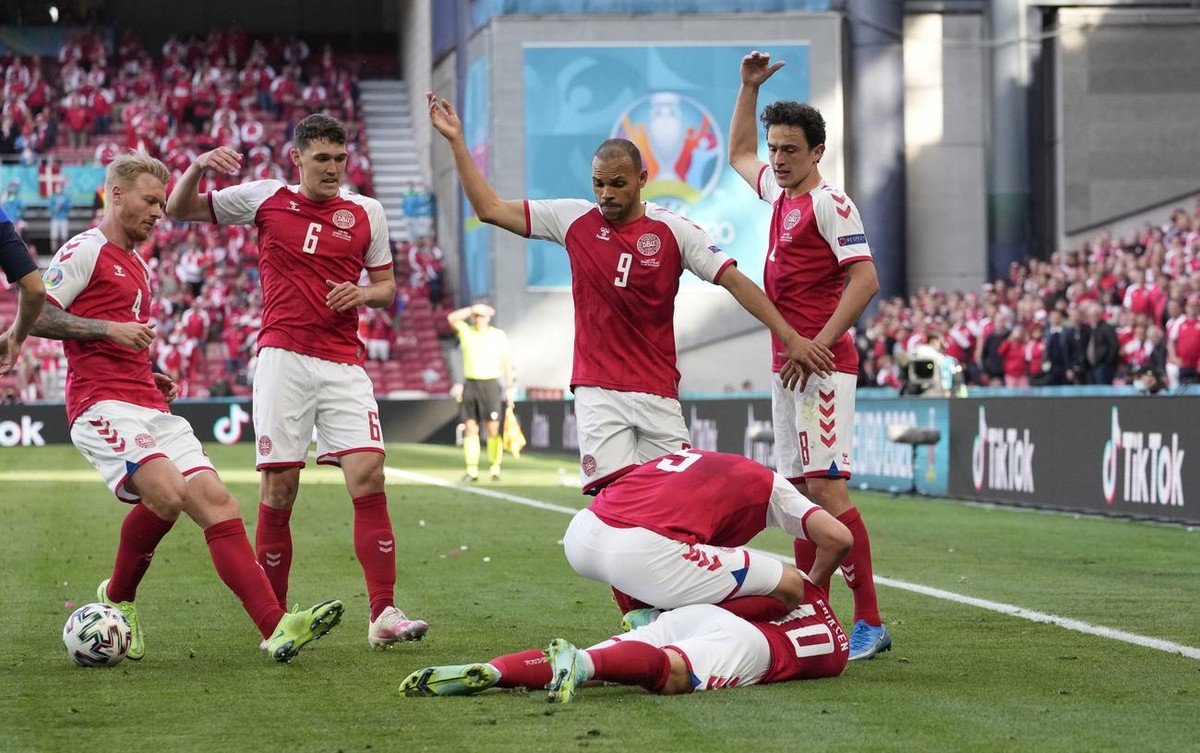 Denmark players run to Denmark's Christian Eriksen fallen on the ground during the Euro 2020 soccer championship group B match between Denmark and Finland at Parken Stadium in Copenhagen, Saturda ...