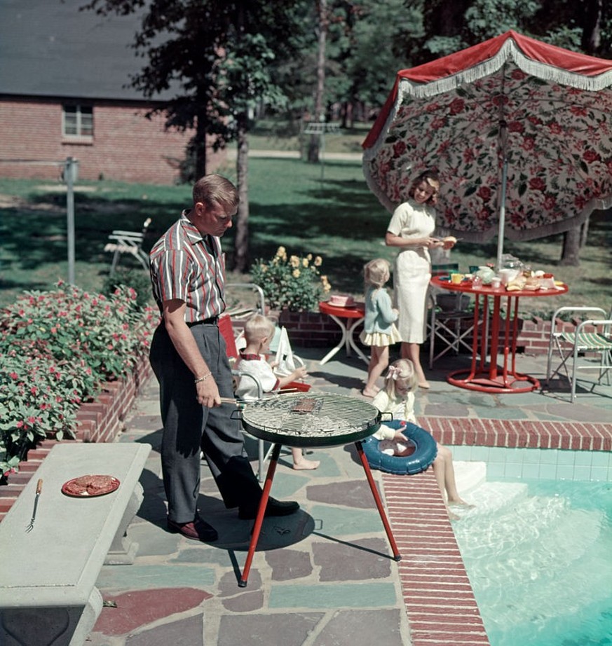 1950s SUBURBAN FAMILY IN BACKYARD BY POOL WITH BAR-B-CUE GRILL (Photo by H. Armstrong Roberts/ClassicStock/Getty Images)