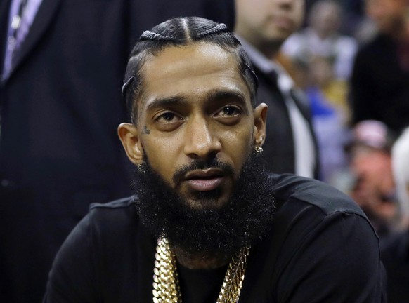 FILE - Rapper Nipsey Hussle attends an NBA basketball game between the Golden State Warriors and the Milwaukee Bucks in Oakland, Calif., March 29, 2018. Three years after rapper Hussle was gunned down ...