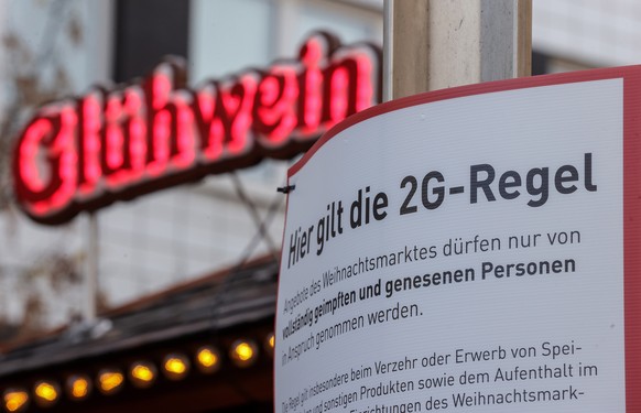 epa09578516 An information sign reading, &#039;Access according to 2G rule: vaccinated, recovered&#039;, is placed at the entrance of the Christmas market in Duisburg, Germany, 12 November 2021. Due t ...